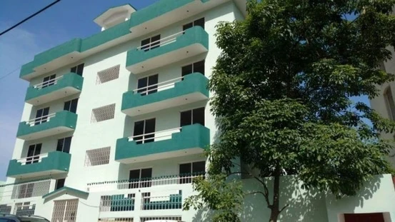 Fachada con balcones curvos turquesa y tubos blancos