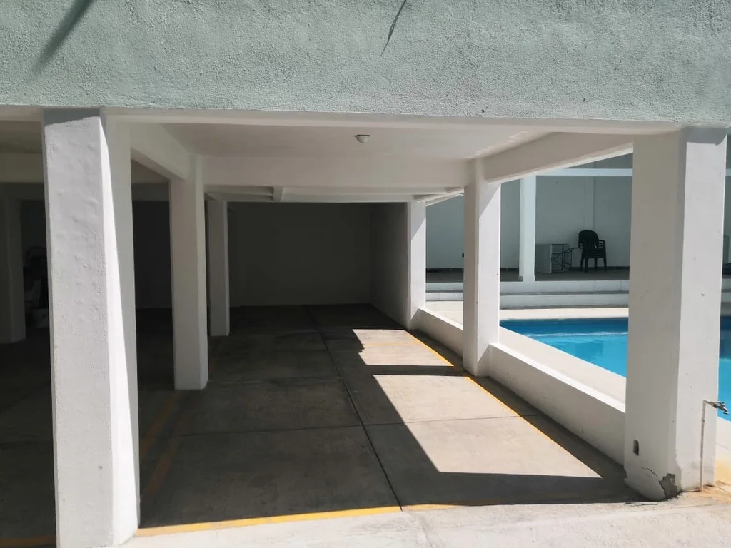 Cajones de estacionamiento cubiertos junto al área de alberca